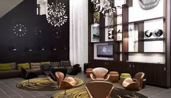 Modern lounge with brown leather chairs and patterned rugs. A wooden shelving unit displays books, globes, and a TV. Black wall features abstract clocks and art. Pendant lights hang from the ceiling, and a gray and green sofa completes the space.